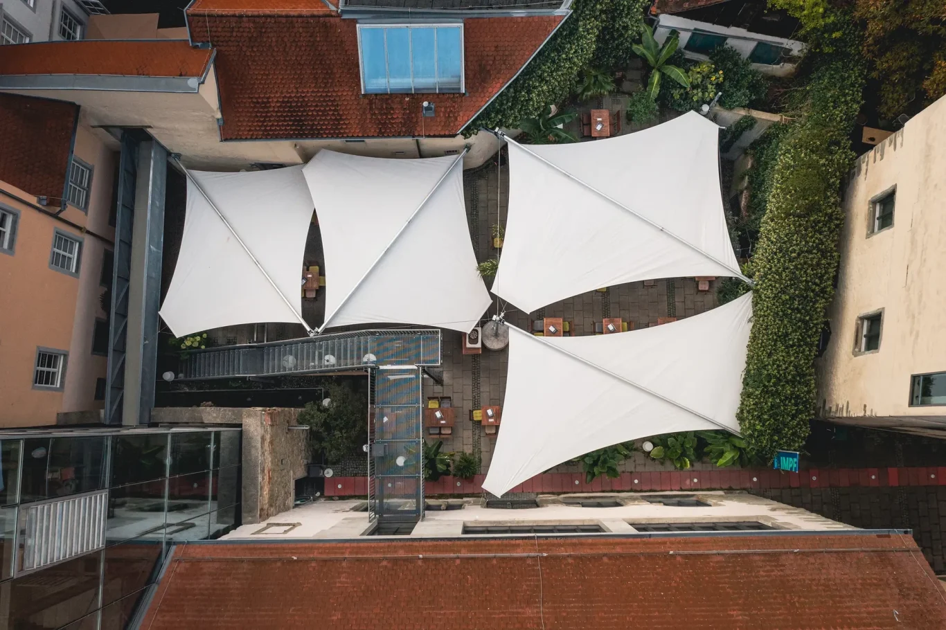 Restaurant Wessenberg, Konstanz. Im historischen Innenhof realisierten wir eine maßgeschneiderte Rollsegelanlage aus der Serie „Textile Bauwerke“ von BIKATEC.